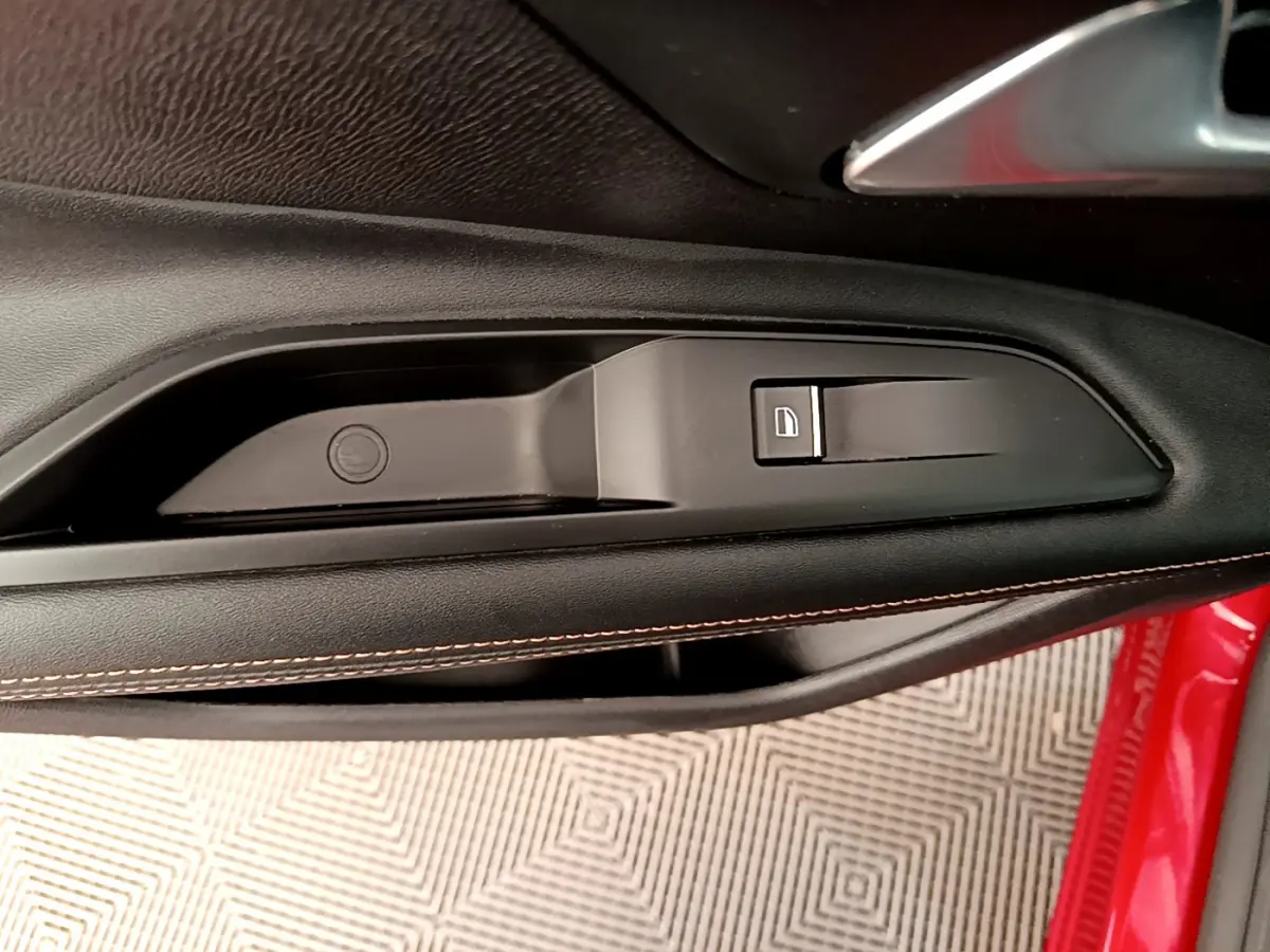Détail de la commande de verrouillage sur la porte intérieure côté conducteur d’un Peugeot 3008 rouge 2021.