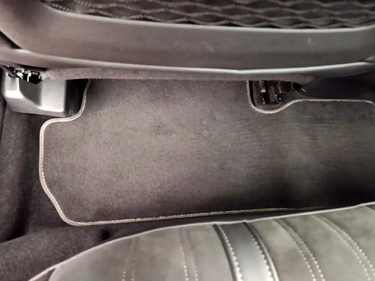 Détail du tapis de sol noir avec surpiqûres beige côté passager arrière du Peugeot 3008 GT rouge 2021.