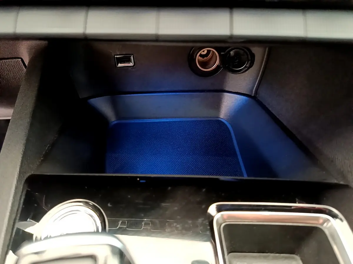 Gros plan sur la console centrale noire avec prise USB et allume-cigare du Peugeot 3008 GT rouge 2021.