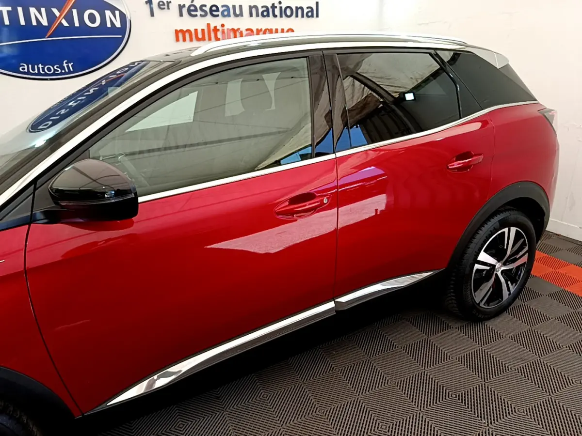 Vue côté droit d’un Peugeot 3008 GT rouge de 2021, avec jantes alliage et détails chromés sur les bas de caisse.
