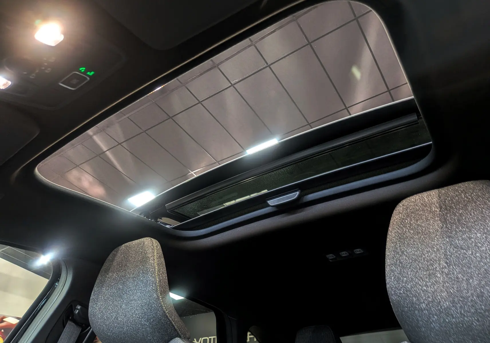 Vue intérieure du toit ouvrant panoramique du Renault Captur E-TECH 2026 avec sièges tissu gris.