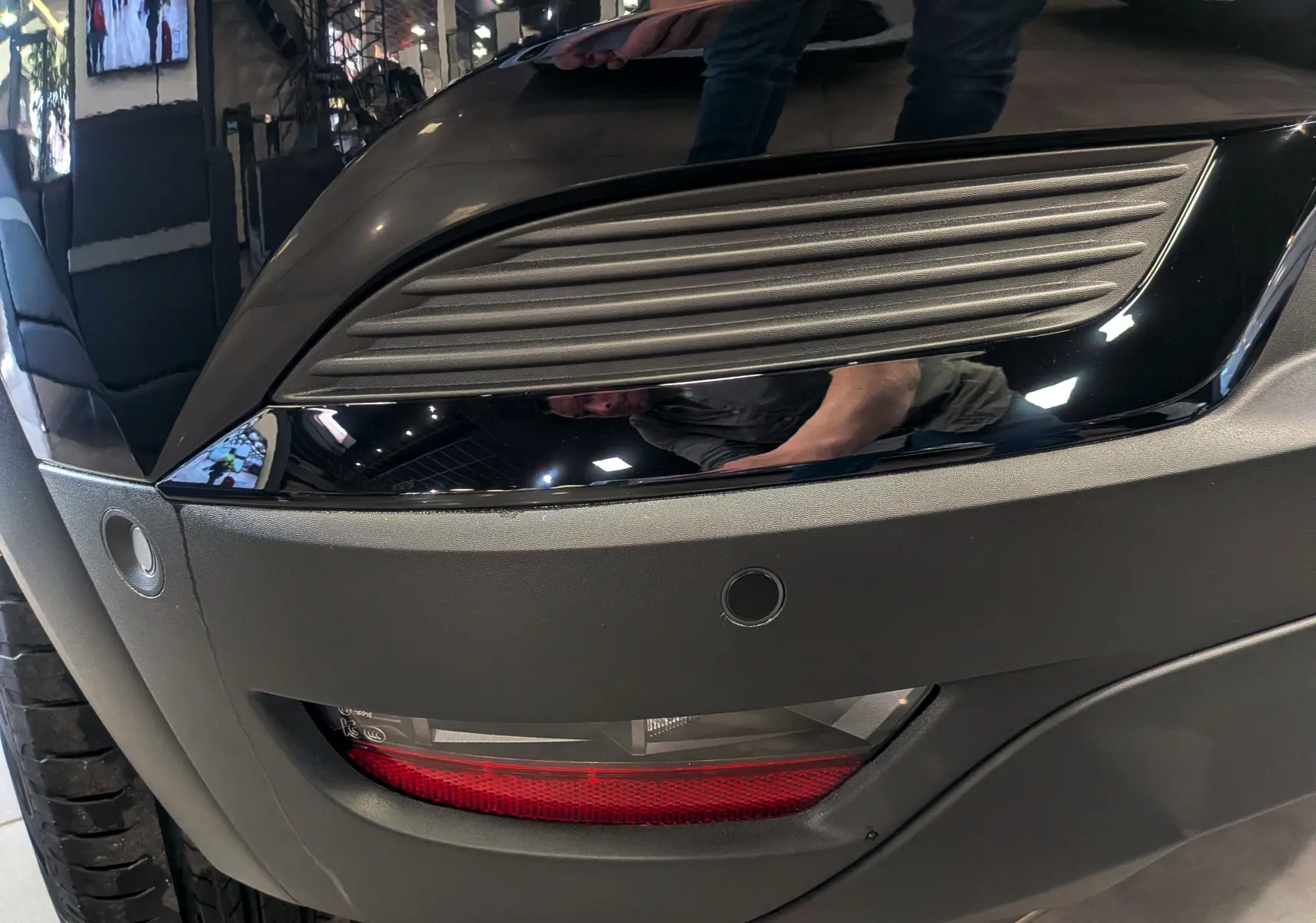 Gros plan sur le feu arrière droit noir et gris du Renault Captur E-TECH 2026, avec capteur de stationnement visible.