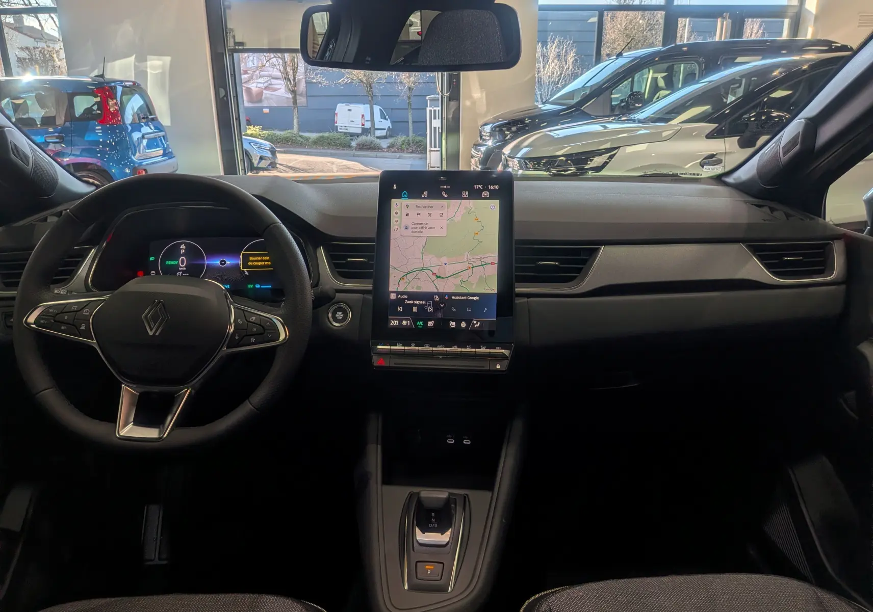 Vue intérieure frontale du tableau de bord du Renault Captur E-TECH avec écran tactile vertical et volant multifonction.