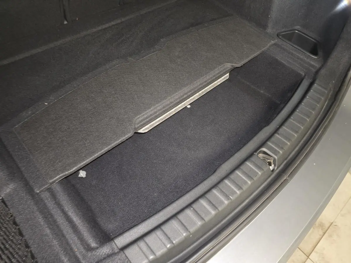 Coffre ouvert en partie avec compartiment de rangement sous plancher, vue arrière, BMW Série 2 gris métallisé.