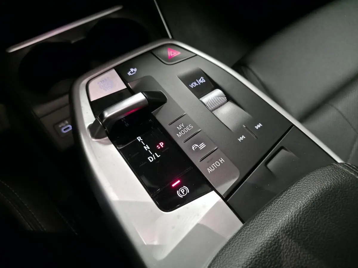 Gros plan sur la console centrale grise et noire de la BMW Série 2 218d Active Tourer avec levier de boîte auto et commandes multifonctions.
