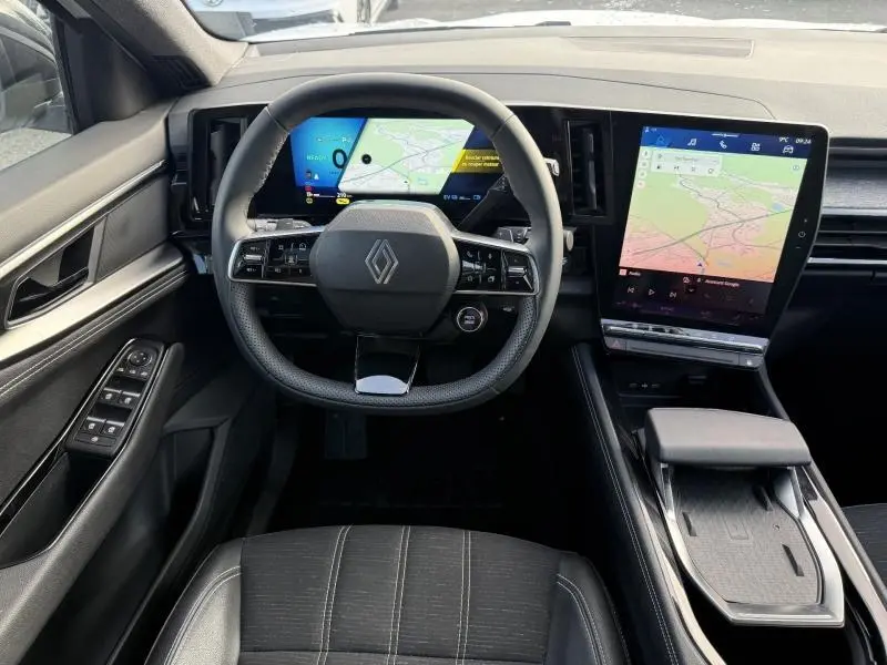 Vue intérieure frontale du Renault Austral 2025, tableau de bord numérique et écran tactile central avec navigation affichée.