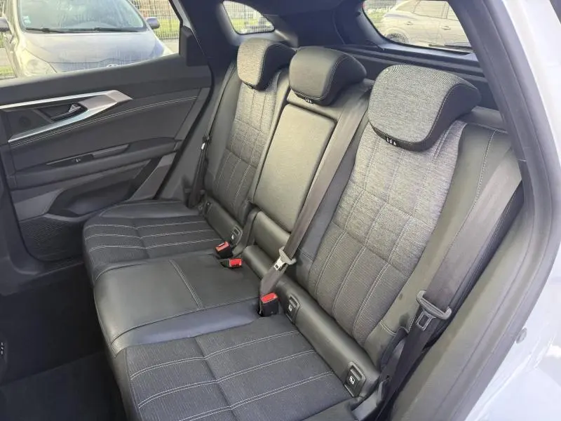 Vue intérieure côté droit des sièges arrière en tissu et cuir noir du Renault Austral 2025 blanc nacré avec toit noir étoilé.