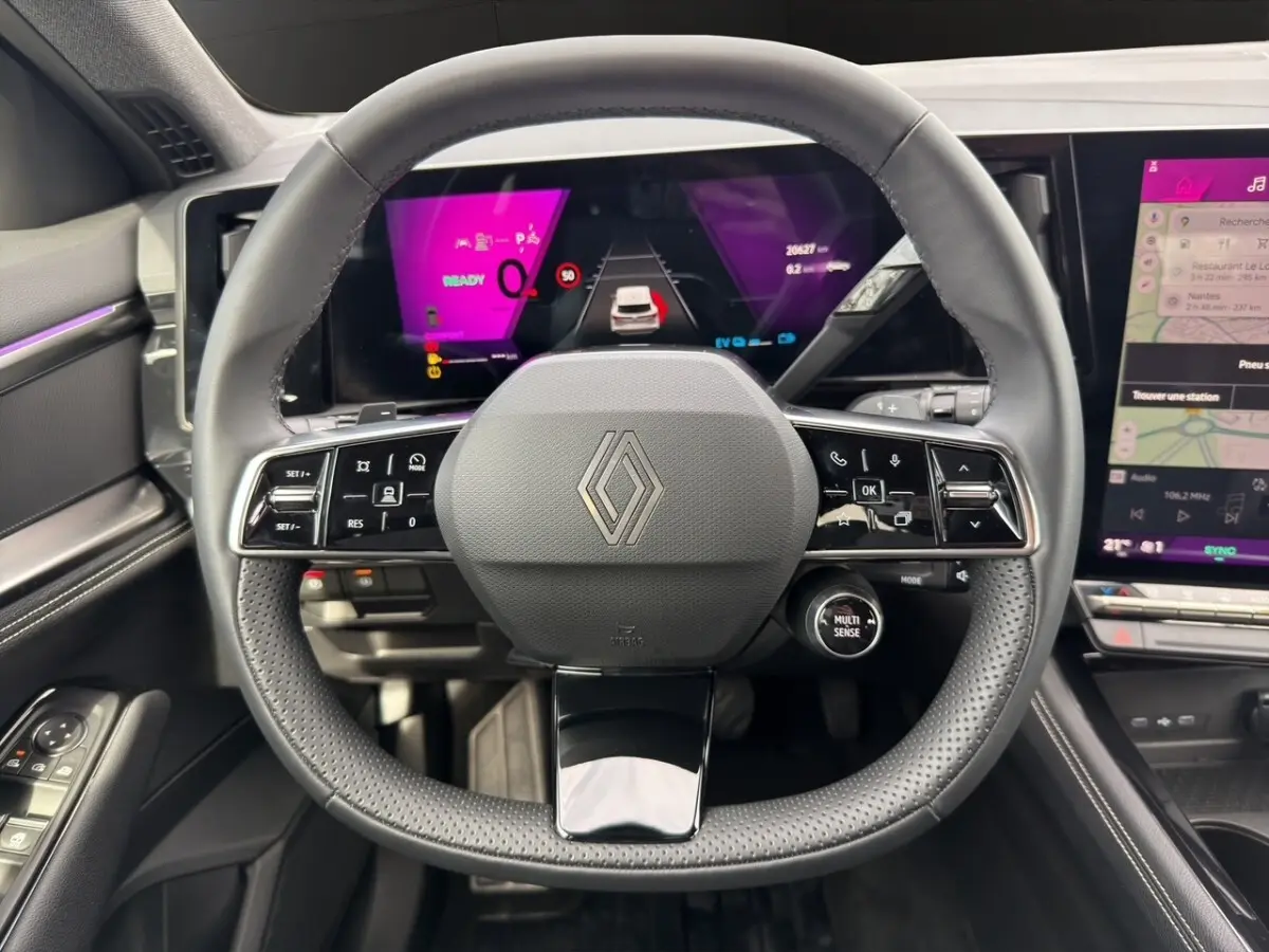 Vue rapprochée du volant cuir noir du Renault Austral 2025 avec tableau de bord numérique et écran tactile latéral.