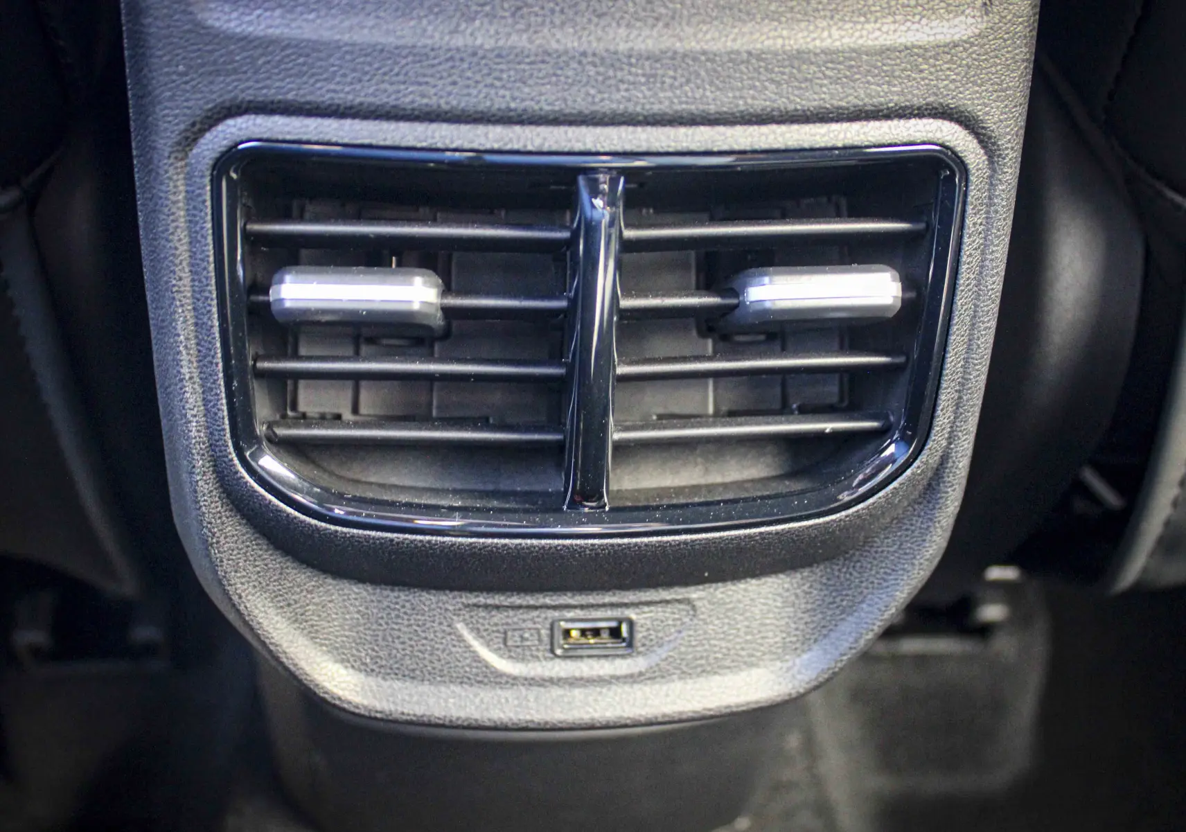 Gros plan sur la sortie d'air arrière noire et la prise USB du MG3 1.5L HYBRID+ 195CH LUXURY 2026 en intérieur.