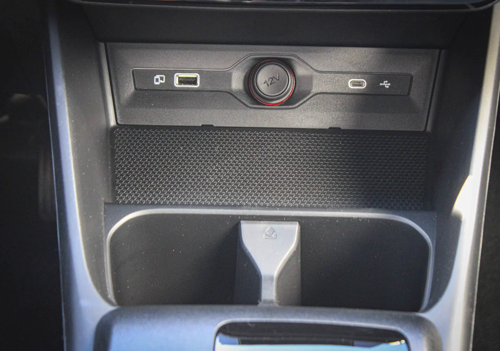 Gros plan sur la console centrale du MG3 1.5L Hybrid+ 195ch Luxury, montrant prises USB, prise 12V et rangement noir.