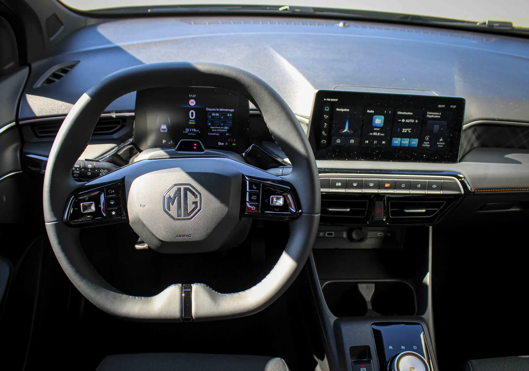 Vue intérieure centrée sur le volant multifonction et l'écran tactile du tableau de bord du MG3 gris.