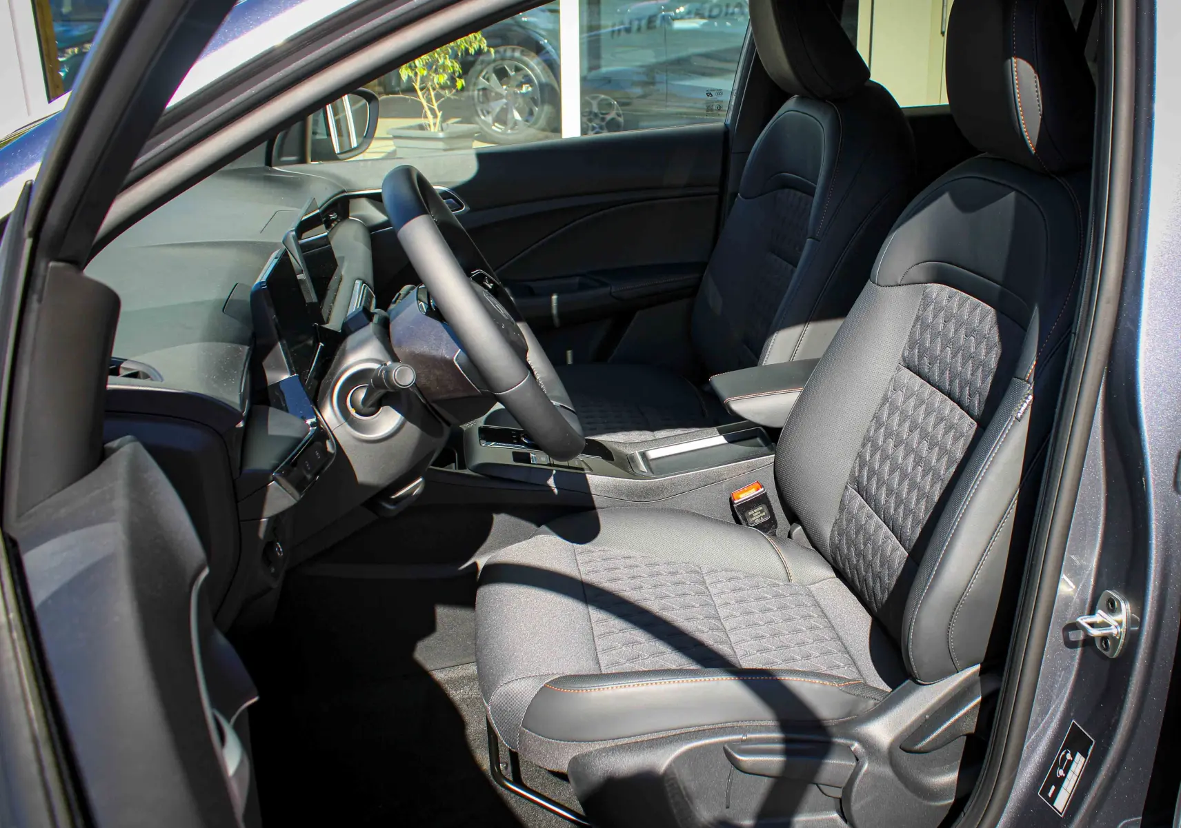 Vue intérieure côté conducteur du MG3 1.5L HYBRID+ 195CH Luxury en gris Hampstead, sièges tissu et cuir avec surpiqûres contrastées.