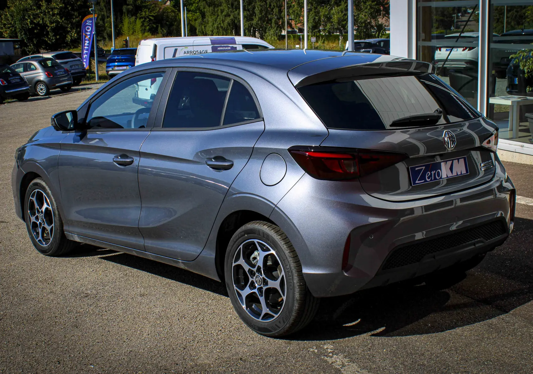 Vue 3/4 arrière droite d’une MG3 1.5L HYBRID+ 195CH Luxury gris métallisé Hampstead avec jantes alliage et vitres teintées.
