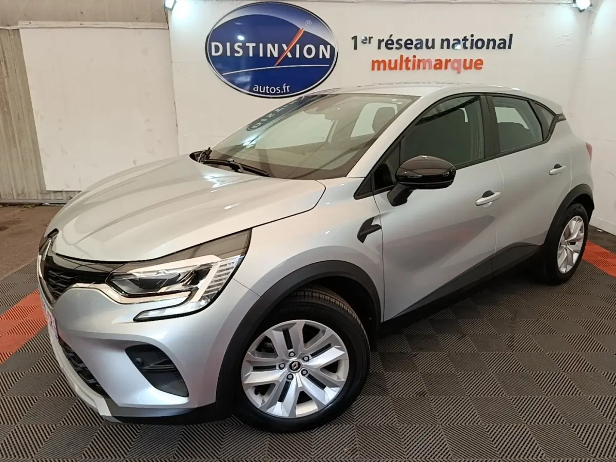 Renault Captur Business E-Tech hybride gris clair vu 3/4 avant droit en intérieur avec jantes alliage et feux LED.