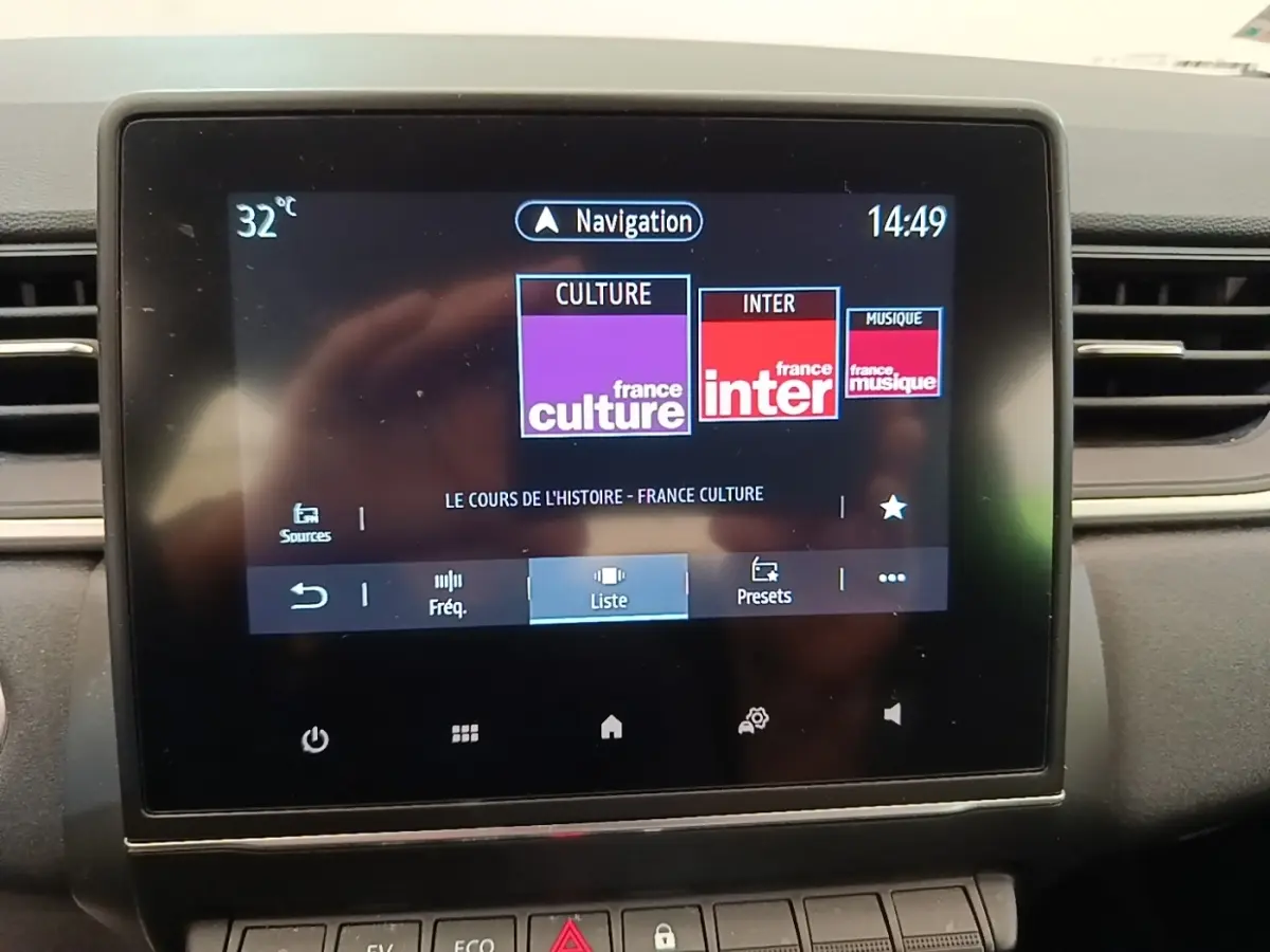 Écran tactile central du tableau de bord du Renault Captur Business E-Tech gris clair, affichant la radio et la navigation.