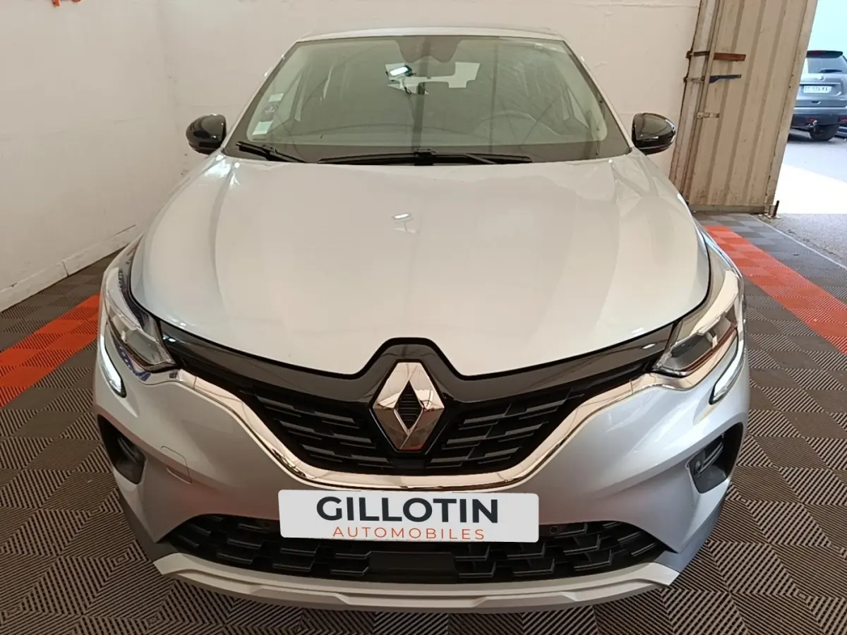Vue avant du Renault Captur Business E-Tech hybride gris clair, mettant en valeur la calandre noire et les phares LED fins.