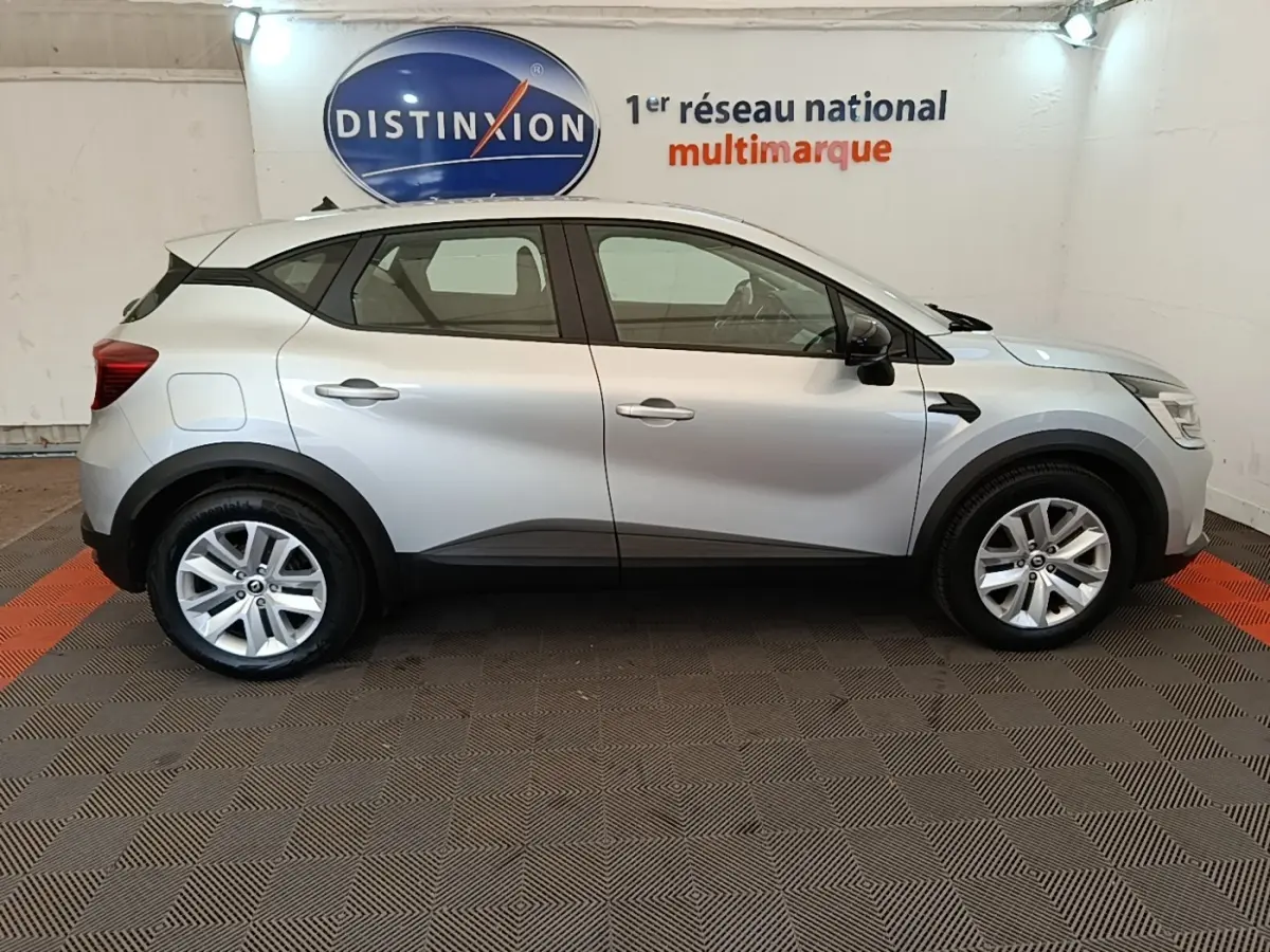 Profil droit d'un Renault Captur Business E-Tech hybride gris clair 2022 avec jantes alliage et protections noires basses.