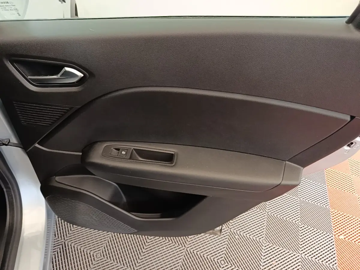 Vue intérieure côté gauche de la porte avant d’un Renault Captur Business E-Tech hybride gris clair avec commande de fenêtre.