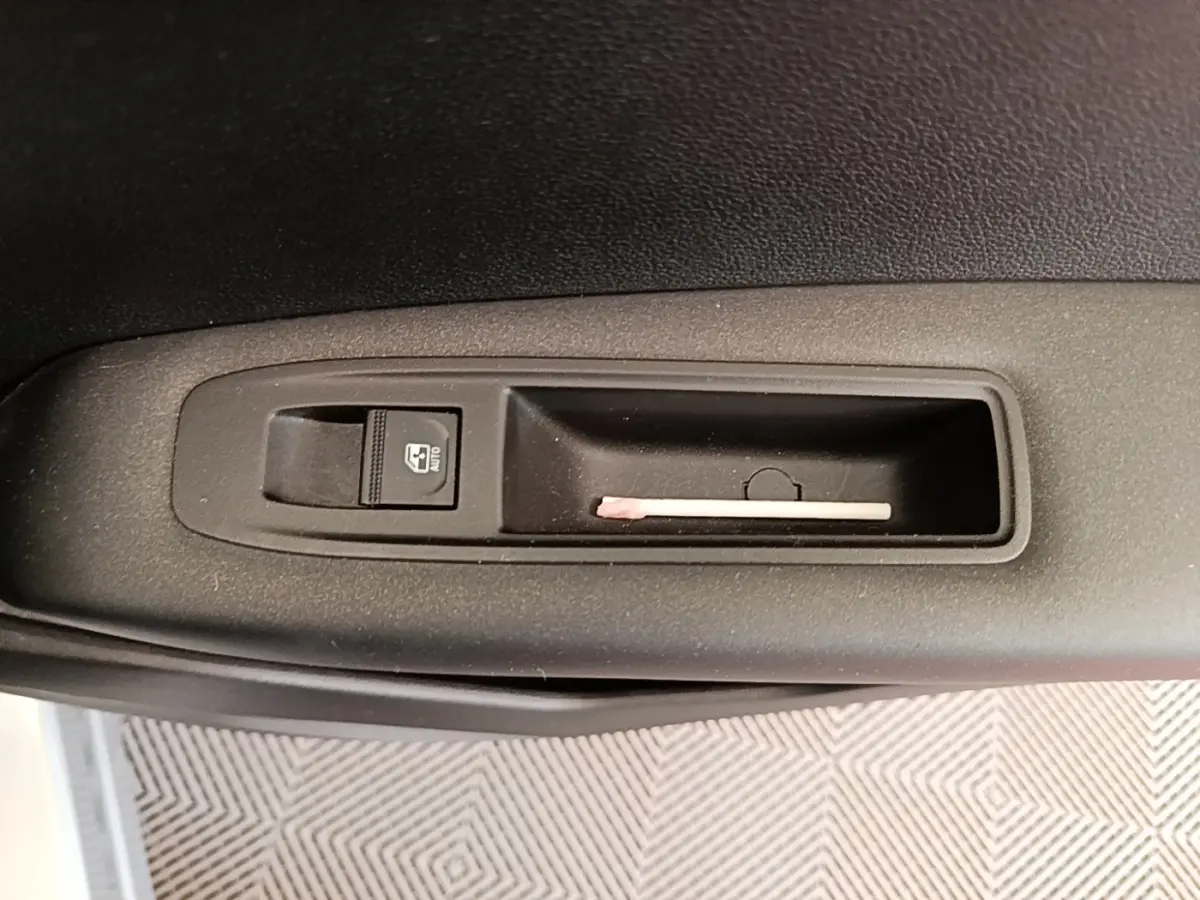 Gros plan sur la commande de lève-vitre côté conducteur du Renault Captur Business E-Tech gris clair 2022.