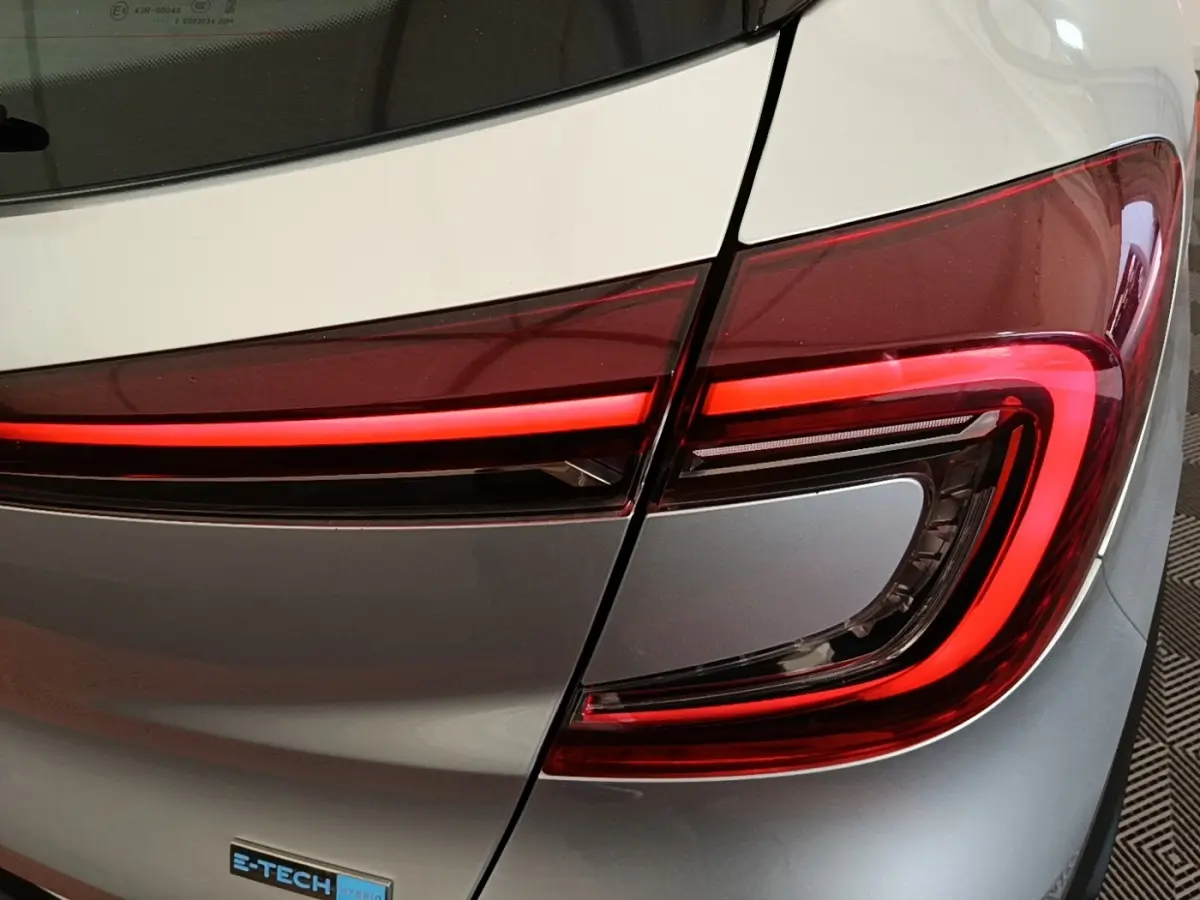 Gros plan sur le feu arrière droit rouge et noir d’un Renault Captur Business E-Tech gris clair 2022.