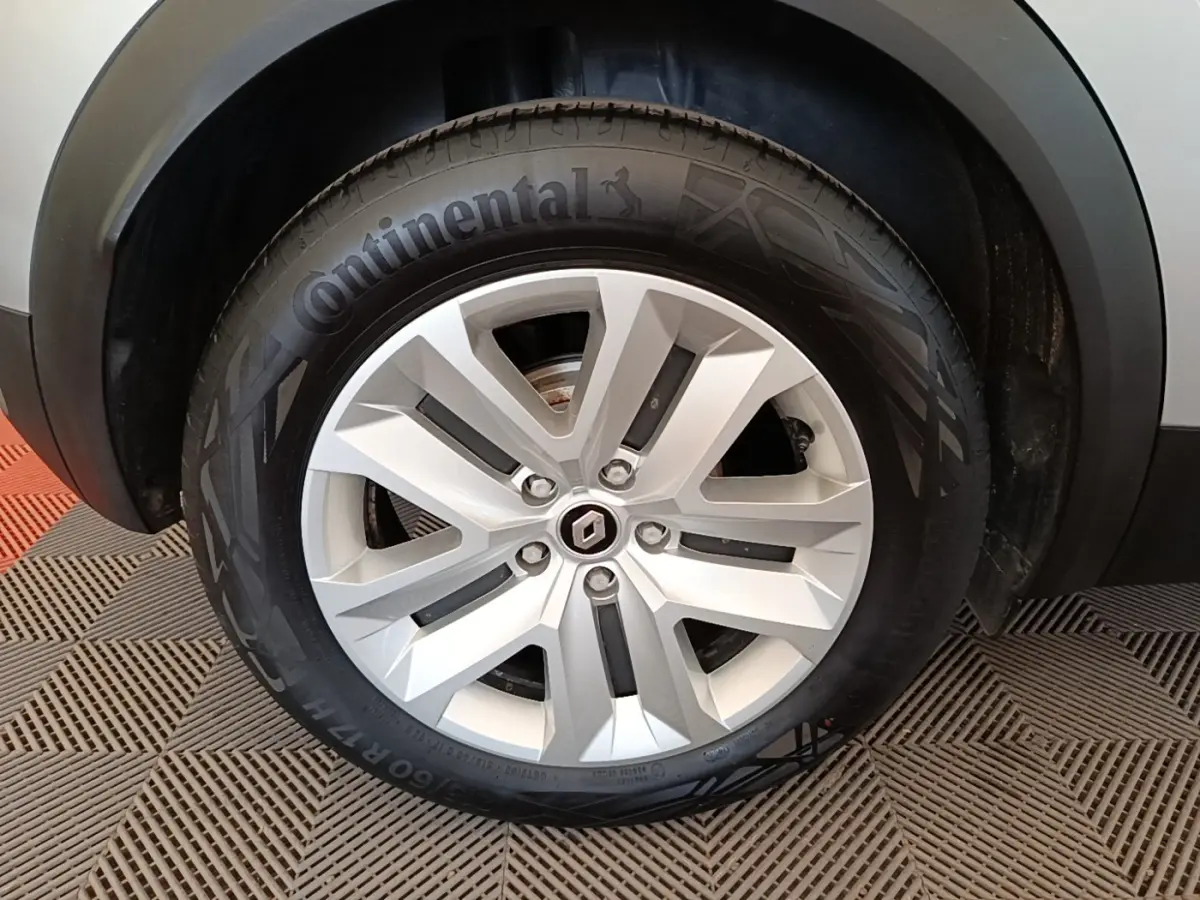 Gros plan sur la roue avant droite du Renault Captur gris clair, mettant en valeur la jante alliage et le pneu Continental.
