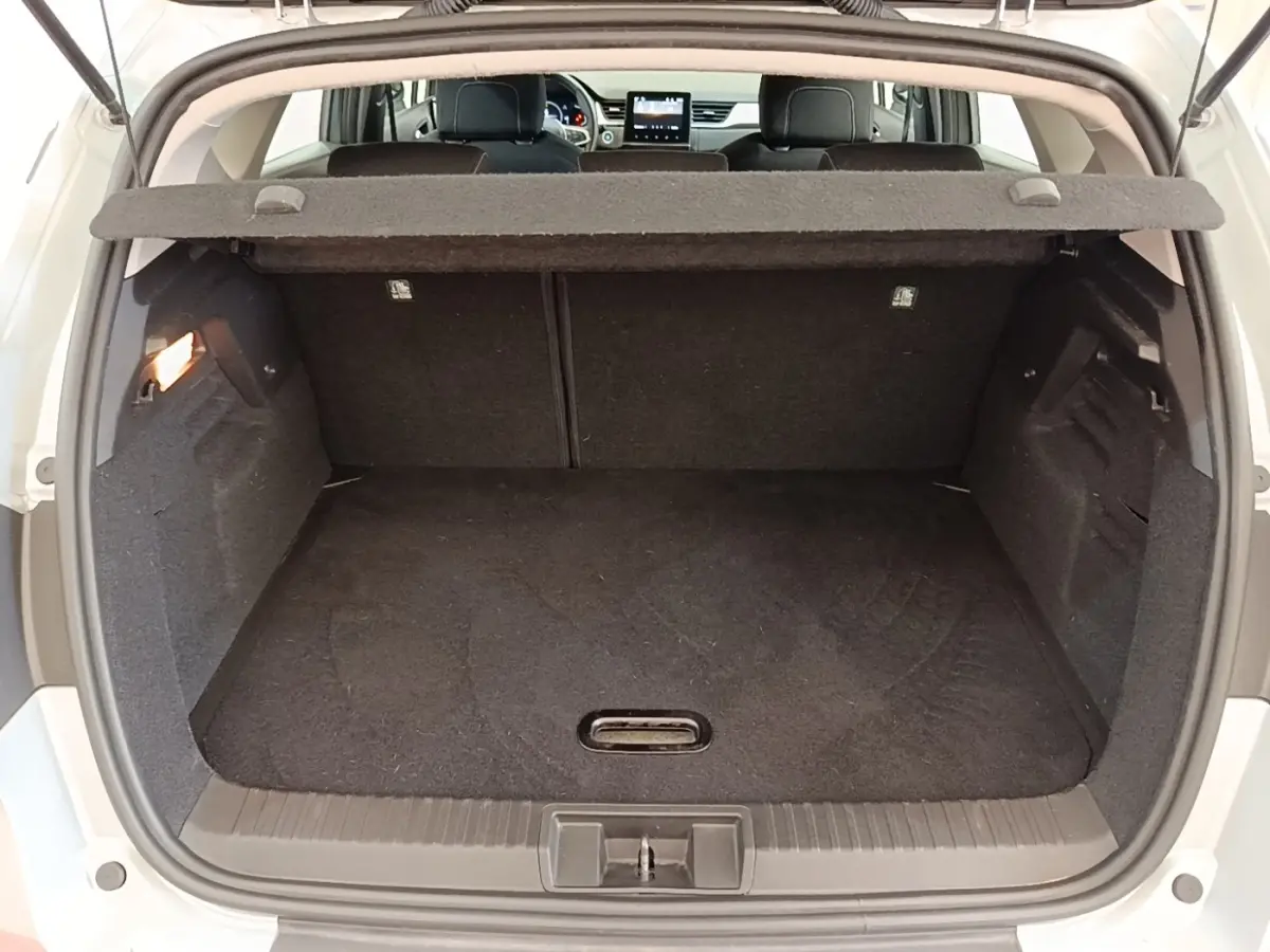 Vue arrière du coffre ouvert d’un Renault Captur gris clair, montrant l’espace de chargement et la tablette cache-bagages.