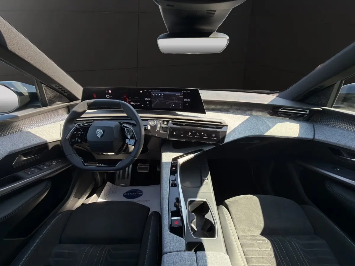 Vue intérieure avant du Peugeot 5008 2025 avec sellerie alcantara noire et tableau de bord numérique panoramique.