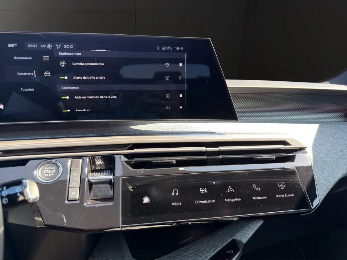 Tableau de bord du Peugeot 5008 2025 avec écran tactile central et commandes numériques en finition noire brillante.