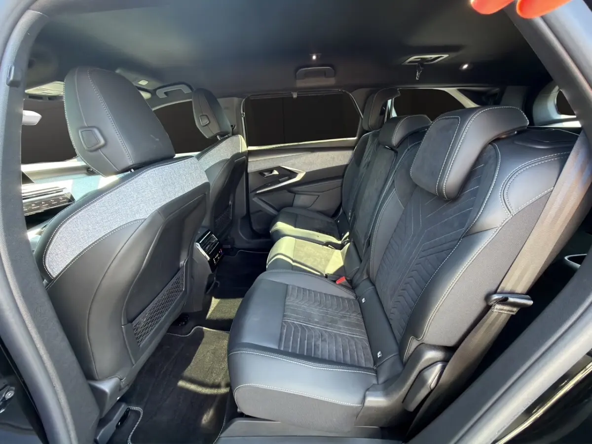 Vue latérale droite de l'intérieur arrière du Peugeot 5008 noir, sièges en Alcantara avec surpiqûres blanches.