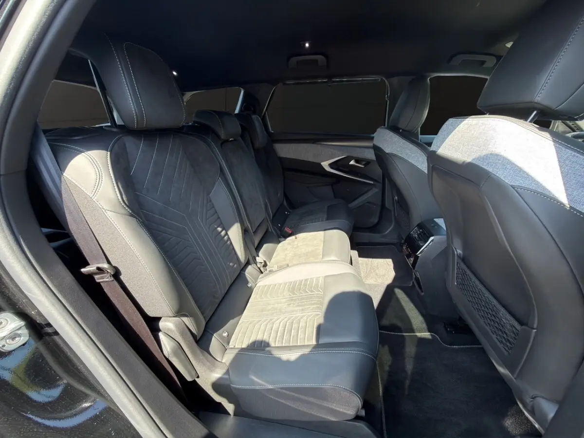 Vue intérieure côté gauche des sièges arrière en cuir et alcantara noirs du Peugeot 5008 2025 avec sellerie Alcantara.