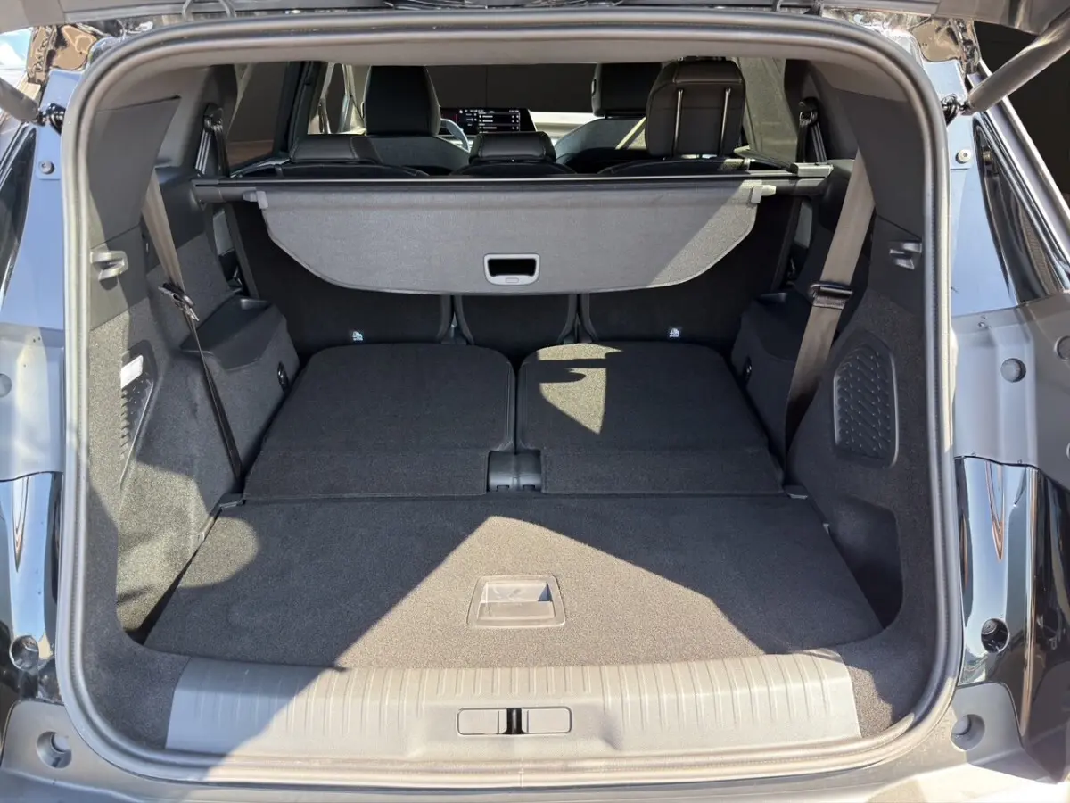 Coffre ouvert d’un Peugeot 5008 noir, vue arrière montrant les sièges rabattus et la tablette de coffre.
