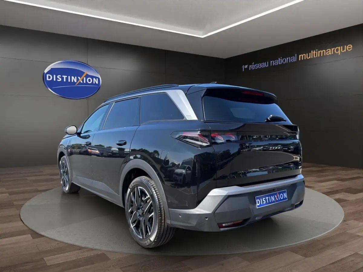 Peugeot 5008 noir vue 3/4 arrière droit, avec jantes alliage et toit ouvrant panoramique visible.