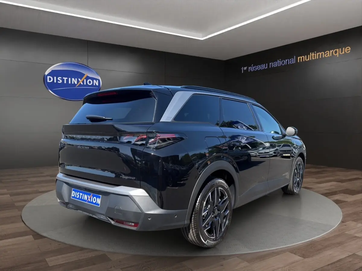 Peugeot 5008 noir vue 3/4 arrière droit, jantes noires, vitres teintées et toit avec rails assortis.