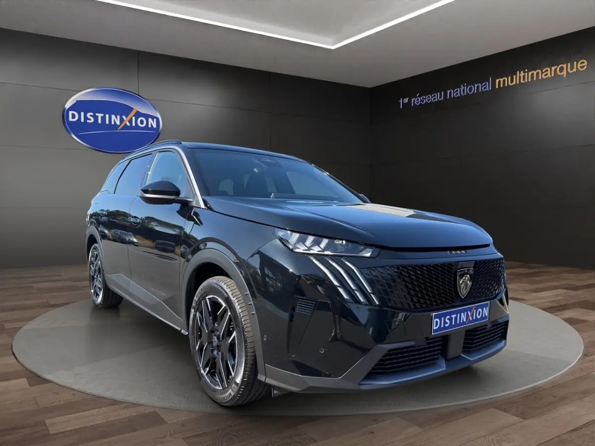 Peugeot 5008 noir en 3/4 avant droit, avec calandre noire distinctive et jantes alliage noires brillantes.