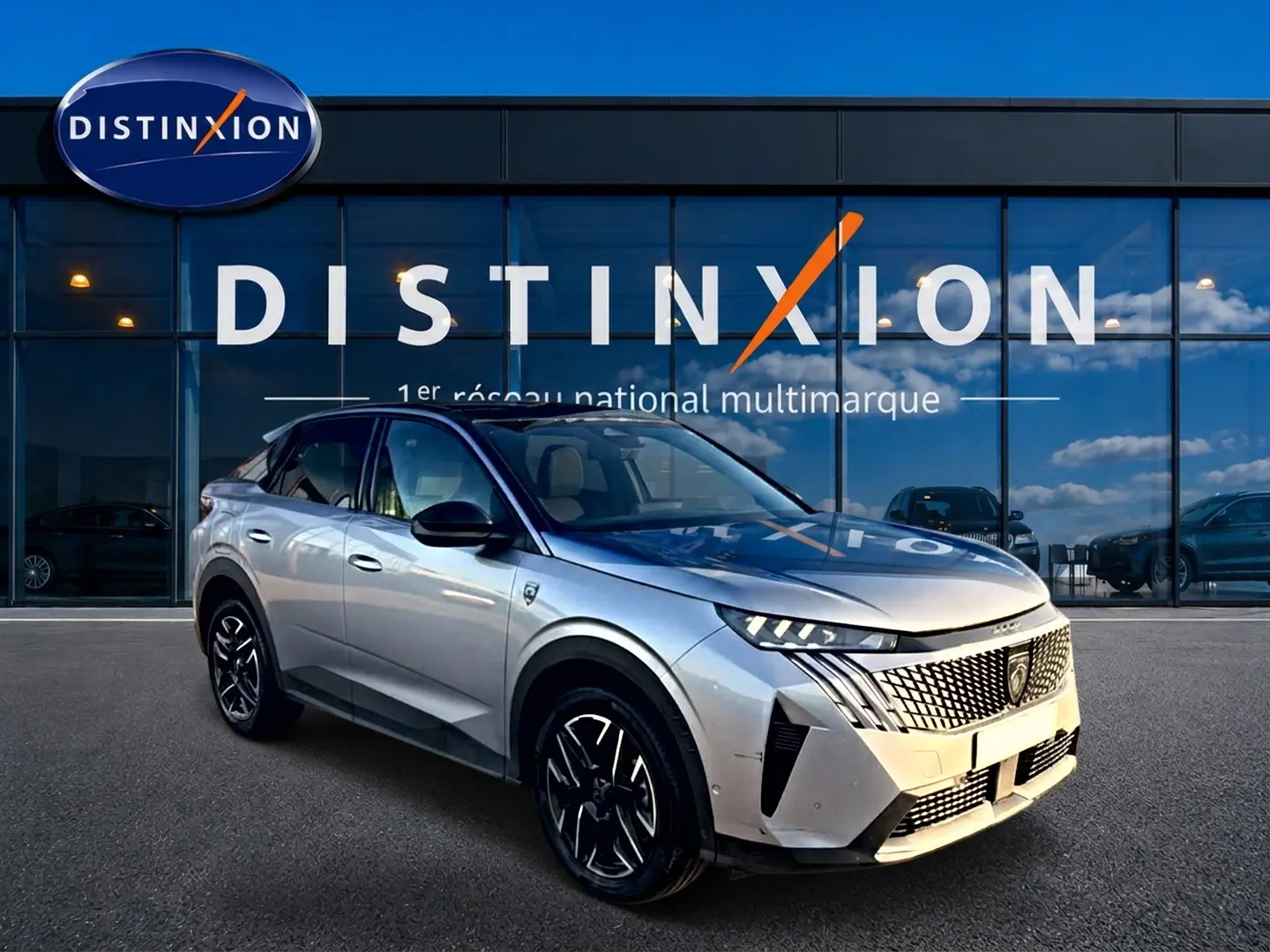 Peugeot 3008 gris 3/4 avant droit avec calandre distinctive et jantes alu noires devant showroom Distinxion.