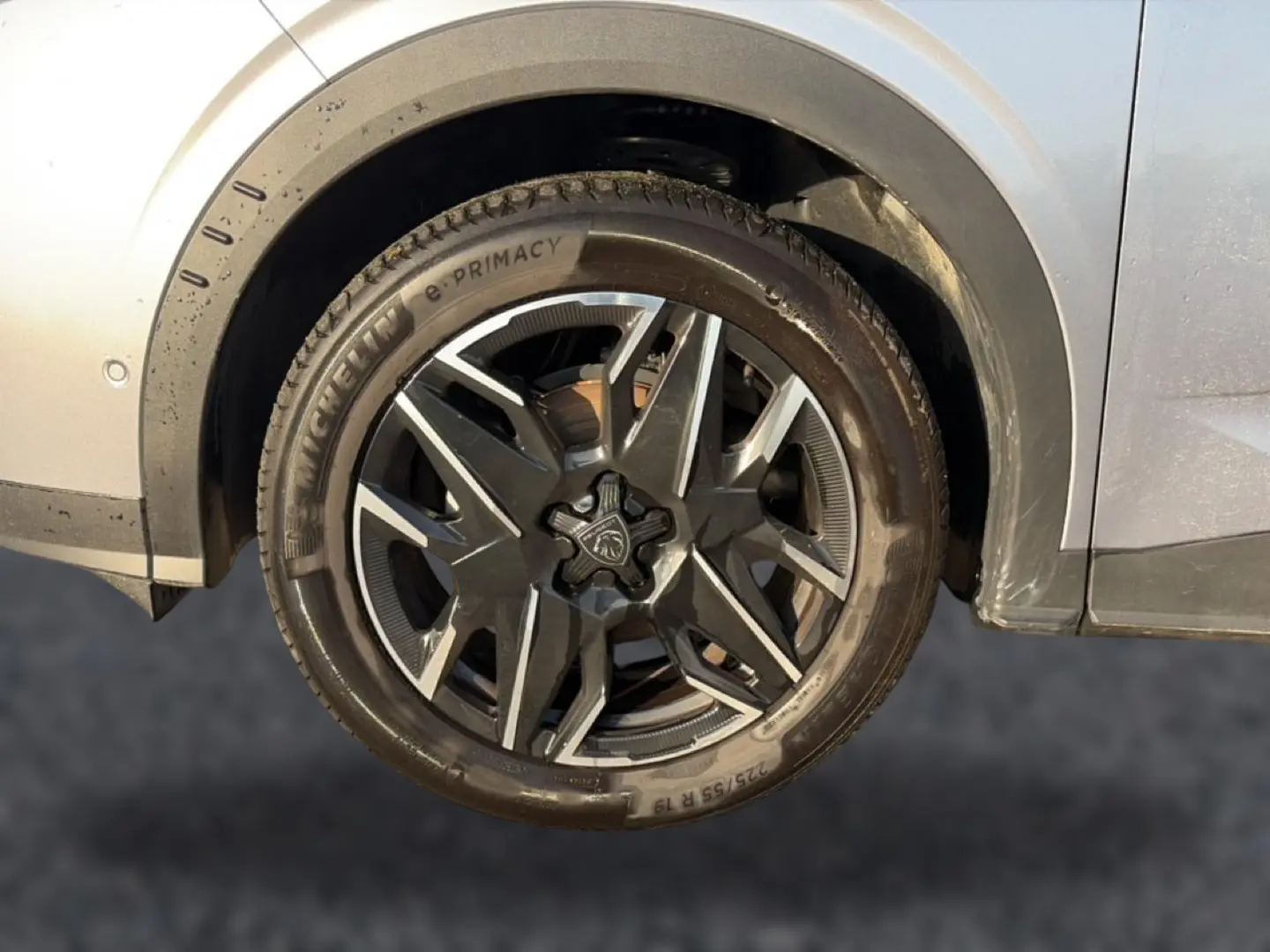 Gros plan sur la roue avant gauche grise d’un Peugeot 3008 1.2 hybrid 145 GT avec jante alu distinctive.