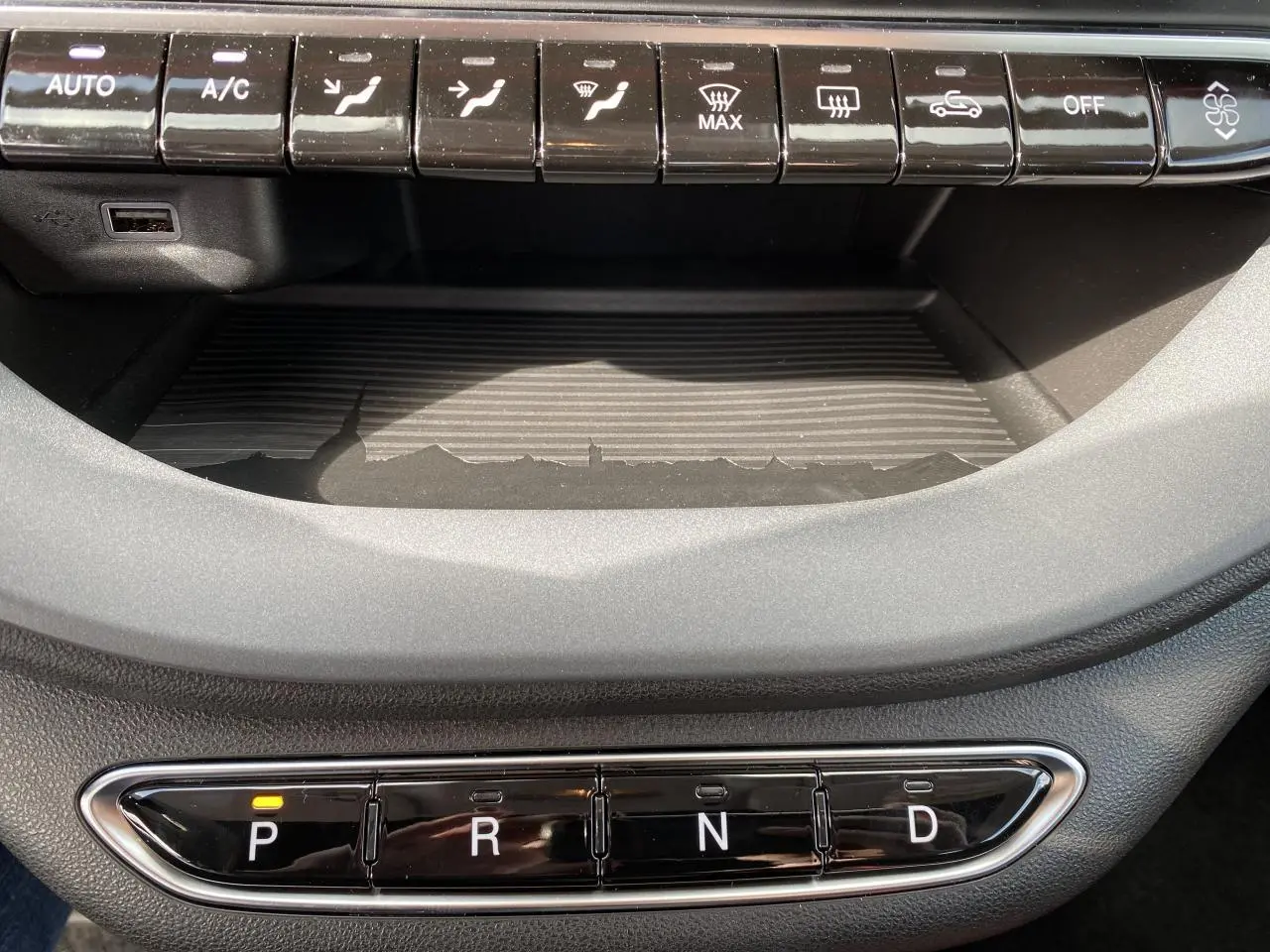 Gros plan sur la console centrale de la Fiat 500 Cabriolet électrique rouge 2022, avec la boîte auto en mode parking P.