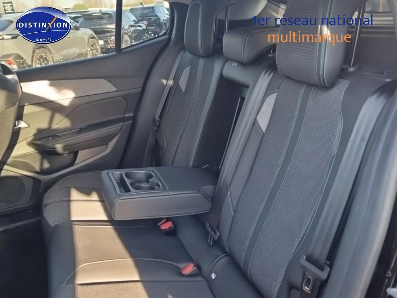 Vue intérieure de la banquette arrière noire du Peugeot 408 Hybrid 145 allure avec accoudoir central et porte-gobelets.