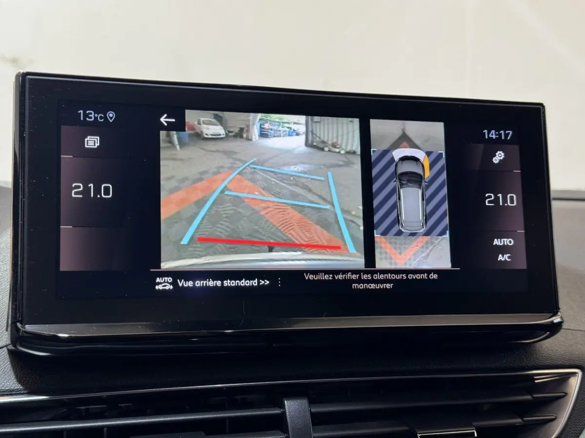 Écran tactile intérieur montrant la caméra de recul et l'aide au stationnement du Peugeot 3008 gris clair, version 2021.