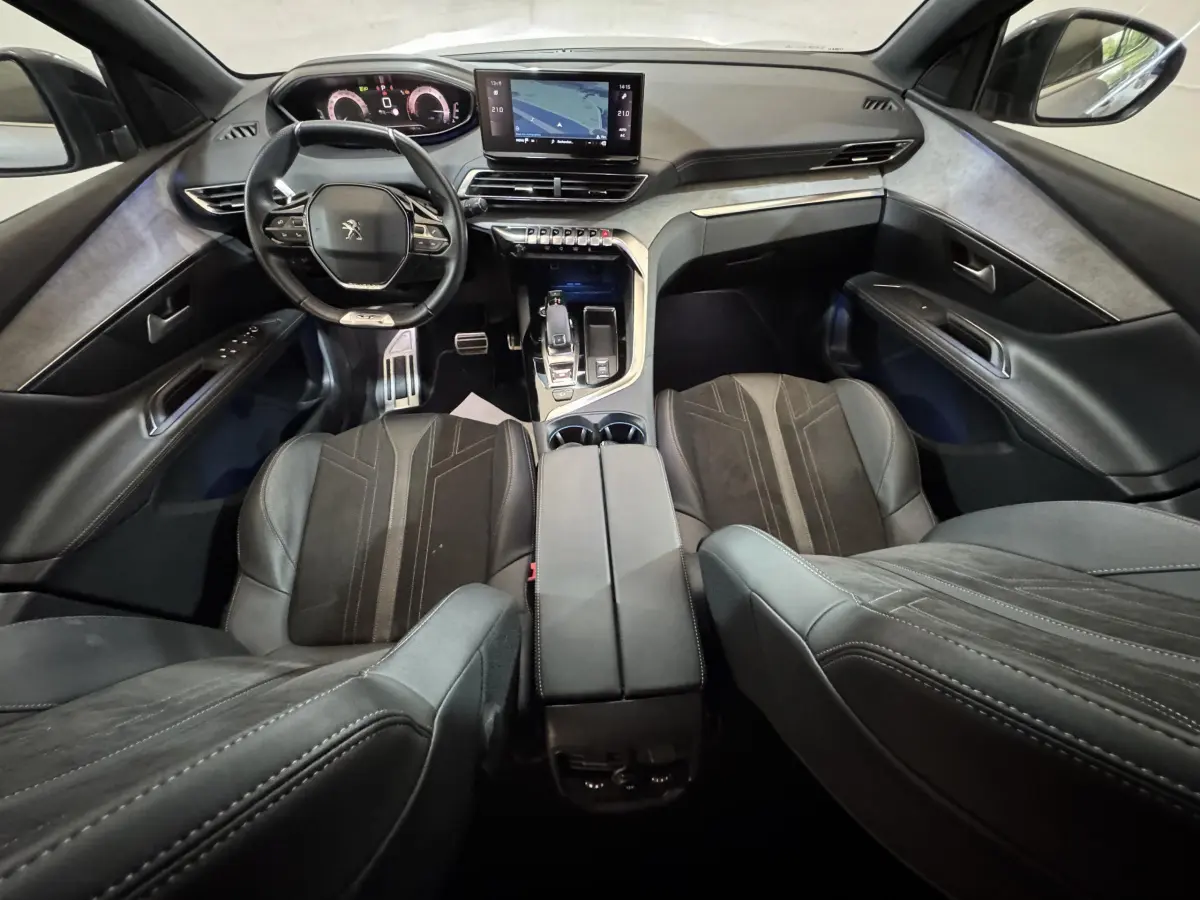 Vue intérieure avant du Peugeot 3008 GT 2021, tableau de bord moderne avec écran tactile et sièges en cuir noir.