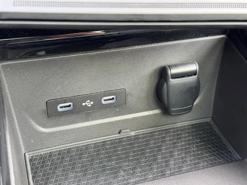 Gros plan sur les ports USB-C et prise 12V dans le rangement intérieur du Renault Austral 2025 bleu Outremer.