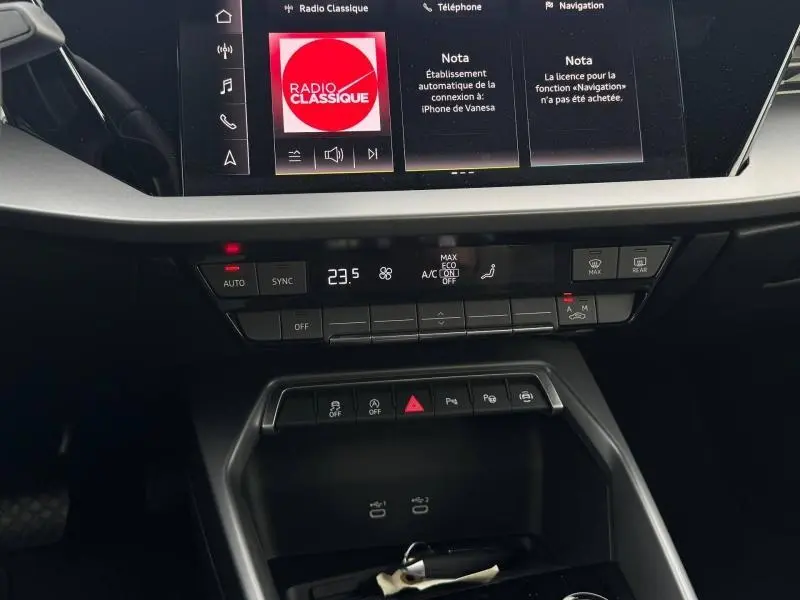 Vue rapprochée du tableau de bord et console centrale de l'Audi A3 Sportback 2024, avec écran tactile et commandes climatisation.