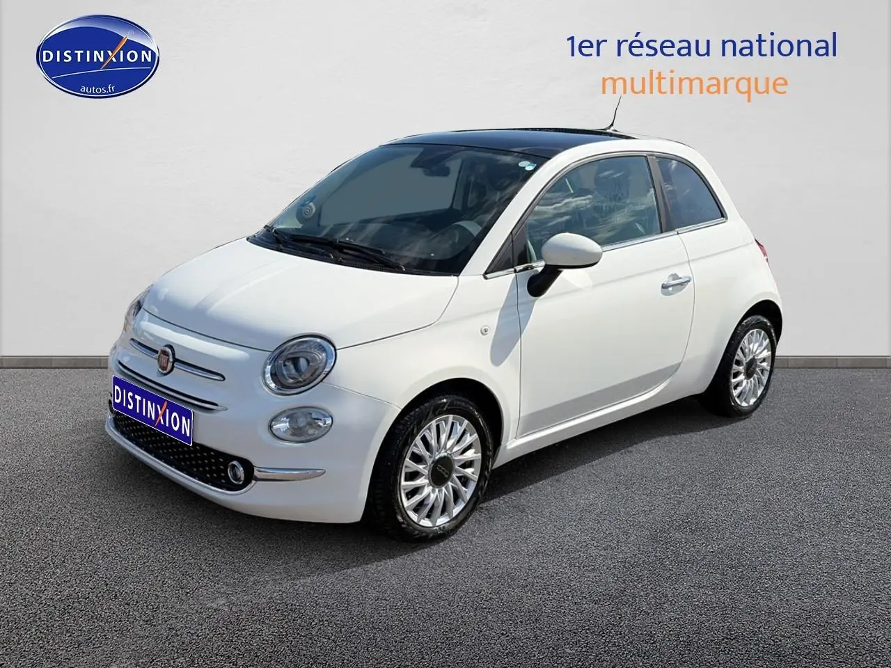 Fiat 500 blanc vue 3/4 avant droit, jantes alliage et toit panoramique en verre visible.