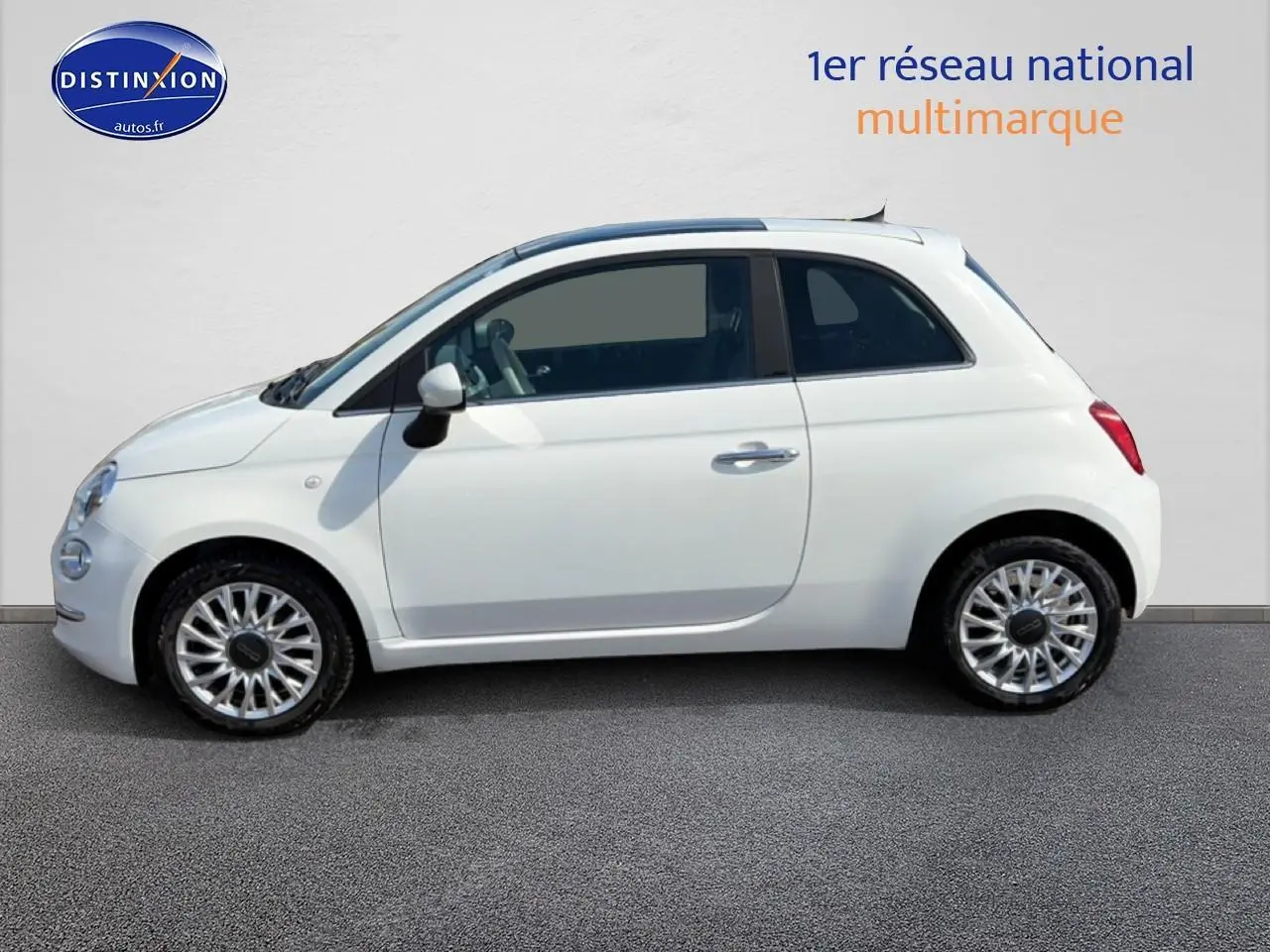 Profil droit d'une Fiat 500 blanche 2023 avec jantes alu et toit panoramique en verre visible.