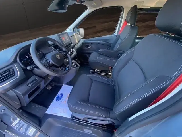 Vue intérieure côté conducteur du Renault Trafic Fourgon gris foncé, avec volant multifonctions et tableau de bord numérique.