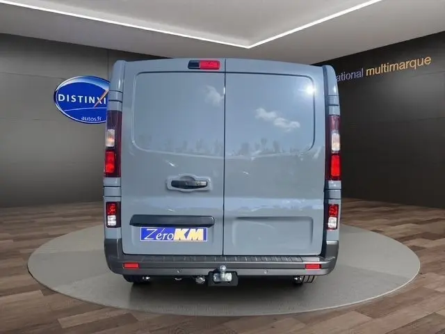 Vue arrière du Renault Trafic Fourgon gris foncé, portes battantes fermées avec attelage visible en bas.