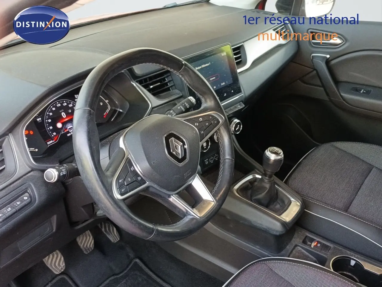 Vue intérieure côté conducteur du Renault Captur TCE90 Intens 2021, volant cuir, boîte manuelle et écran tactile central.