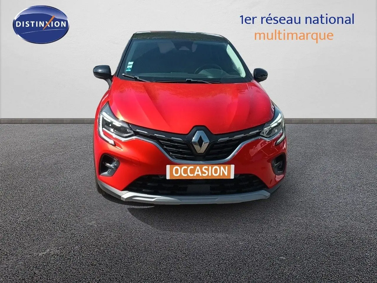 Vue avant d'un Renault Captur TCe90 Intens rouge avec toit noir, calandre chromée et feux LED allumés.