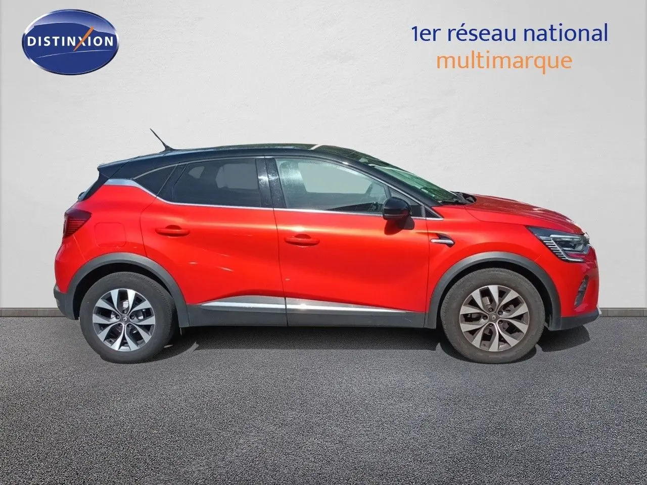 Profil droit du Renault Captur TCE90 Intens 2021 rouge avec toit noir, jantes 17 pouces bi-ton et détails noirs contrastants.