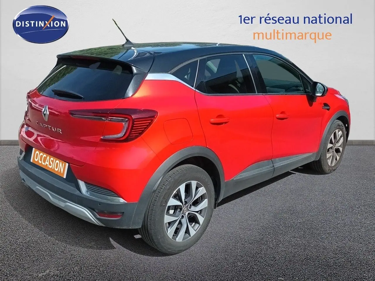 Vue 3/4 arrière droite d’un Renault Captur TCE90 Intens rouge avec toit noir et jantes alliage biton.
